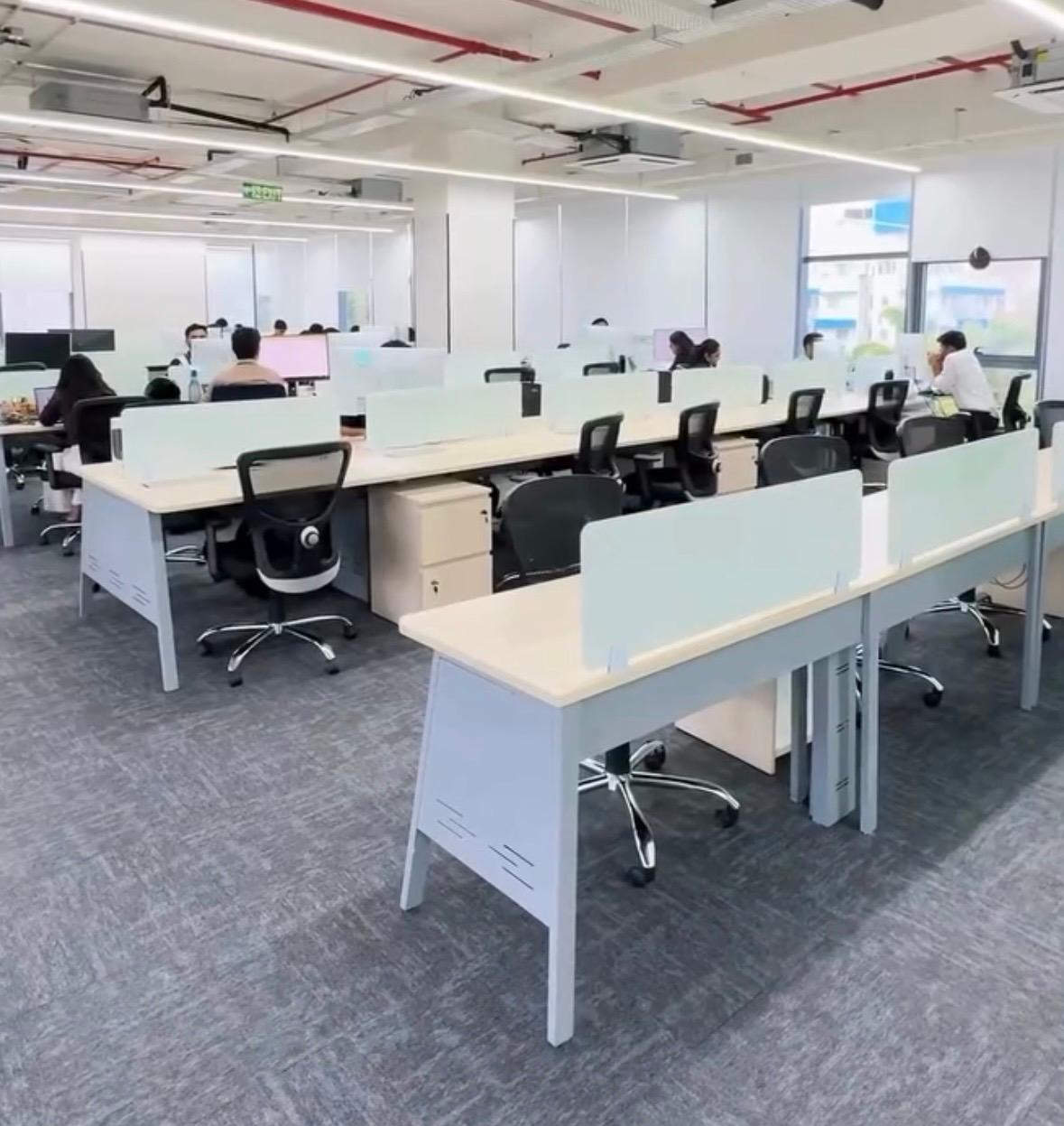 Wide expansive view of the modern, bustling open-plan office